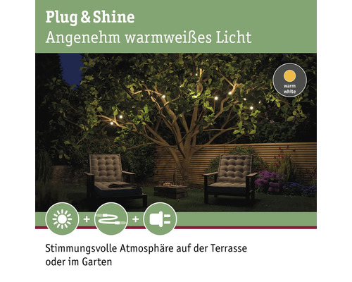Gartenambiente mit warmweißer Lichterkette, Gartensesseln und Holzzaun