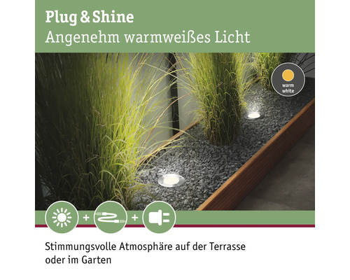 Szene mit Plug and Shine Gartenleuchten in einem Kiesbeet mit Gräsern