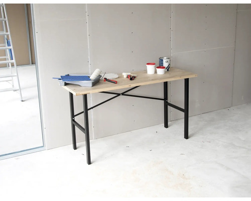 Szene mit Tapeziertisch, Farbe, Farbroller und Werkzeugen in einem Raum.