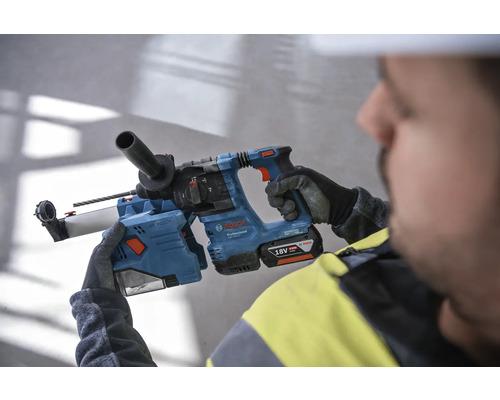Ein Arbeiter hält einen blauen Bohrhammer von Bosch mit einem 18 Volt Akku.