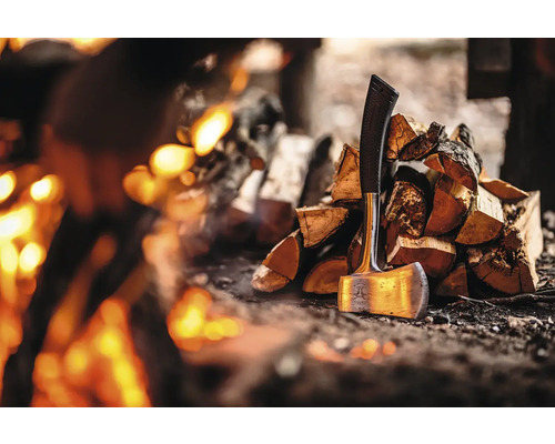 Axt neben Holzstapel vor Feuer