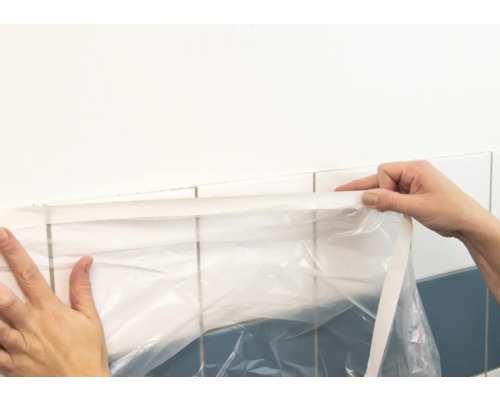 Abdeckfolie wird an Fliesen angebracht.