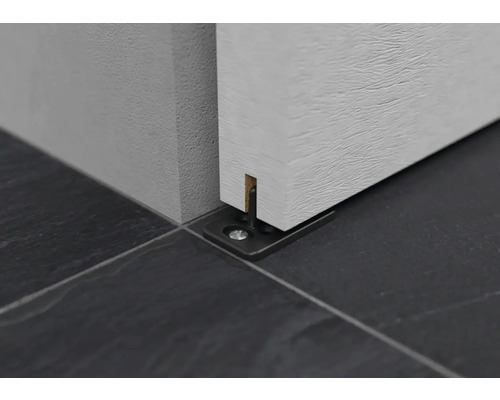 Detailansicht einer Schiebetürführung auf dunklem Fliesenboden