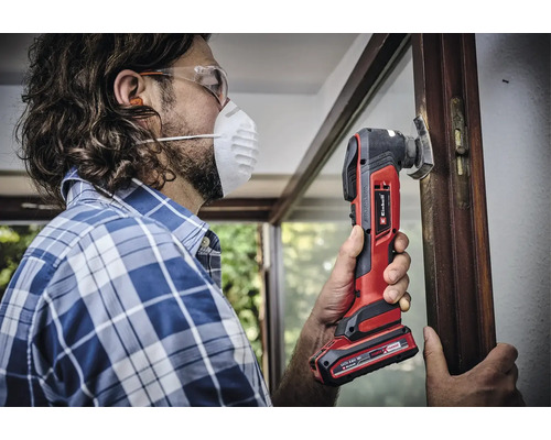 Mann arbeitet mit einem Einhell Multifunktionswerkzeug an einem Fensterrahmen