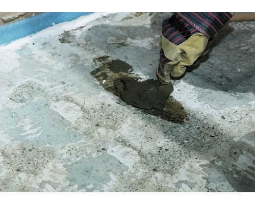 Auftragen von Ausgleichsmasse auf einen Untergrund mit einer Kelle.