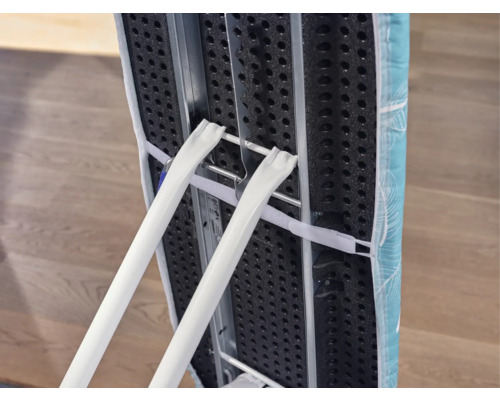 Zusammengeklapptes Bügelbrett mit Bezug