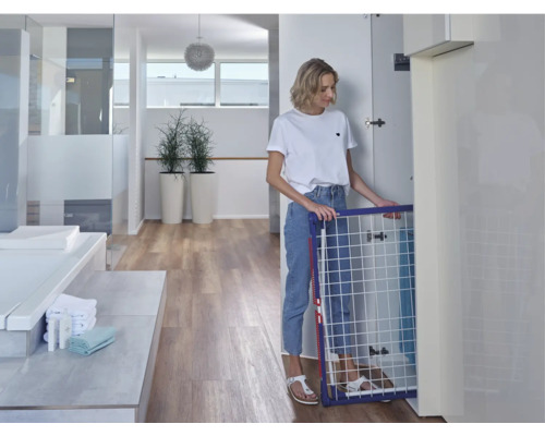 Frau faltet Wäscheständer im Badezimmer zusammen