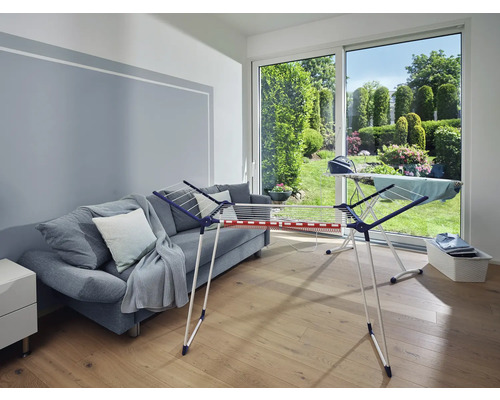 Wohnzimmer mit Wäscheständer, Bügelbrett und Sofa