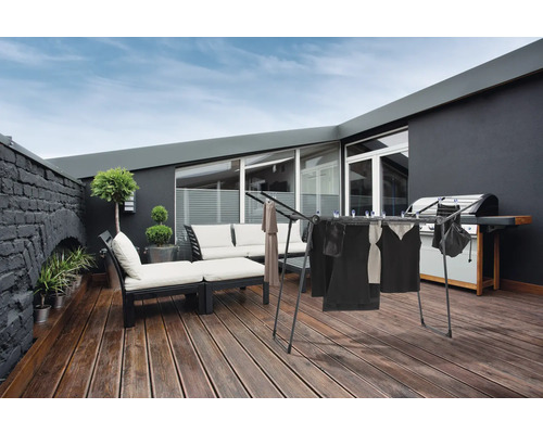 Wäscheständer auf einer Terrasse mit Grill und Sitzgelegenheiten