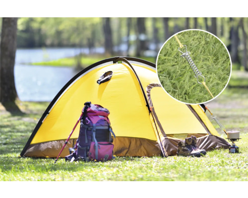 Gelbes Zelt auf einer Wiese mit Rucksack, Wanderstöcken und Campingkocher. Detailaufnahme von Zeltfeder