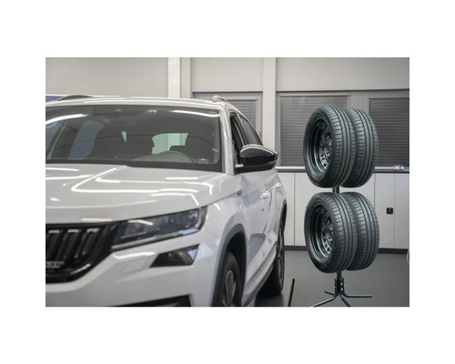 Reifenständer mit vier Reifen neben einem Auto
