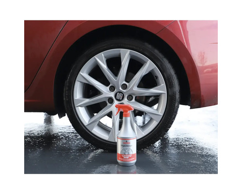 Felgenreiniger-Sprühflasche vor einem Auto mit Alufelgen