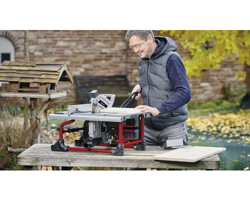Mann arbeitet im Freien mit einer Tischkreissäge zum Holzzuschnitt