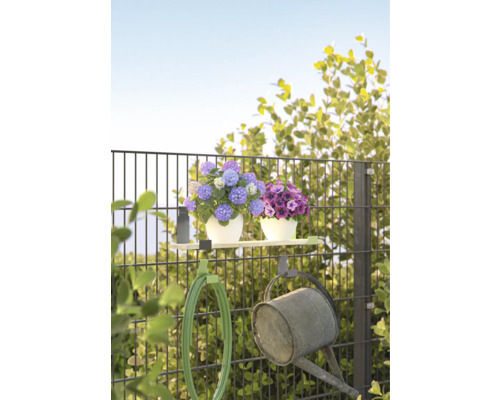 Gartenzaun mit Blumen, Gartenschlauch und Gießkanne