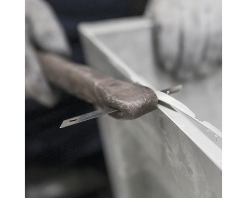 Handwerker verwendet Messer, um Dichtungsmasse aufzutragen.