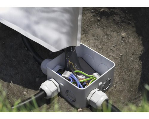 Installierte Abzweigdose mit Erdkabel im Erdreich