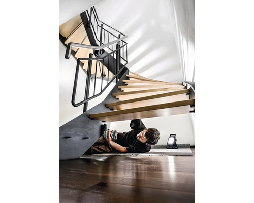 Mann montiert eine Wendeltreppe mit einem Akku-Bohrschrauber