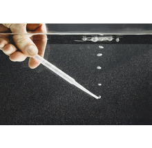 Hand hält Pipette unter Wasser