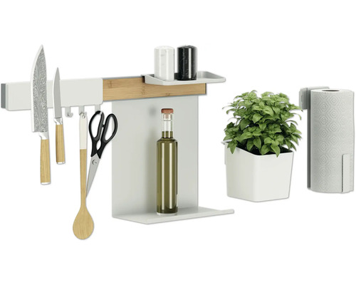 Küchenutensilien an einer Küchenleiste mit Messer, Schere, Kochlöffel, Ölflasche, Kräutertopf, Küchenrollenhalter