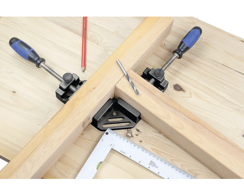 Werkbank mit Holz, Schraubzwingen, Winkel und Bohrer