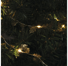 Dekorationslichterkette mit Stechpalmenblättern auf einem Weihnachtsbaum