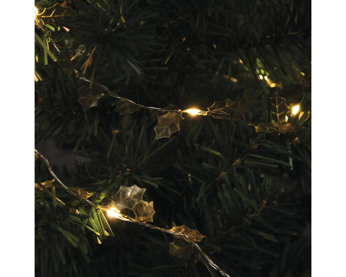 Dekorationslichterkette mit Stechpalmenblättern auf einem Weihnachtsbaum
