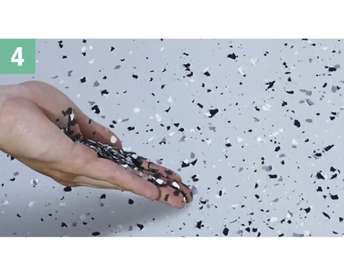 Eine Hand streut Dekor-Chips auf einen Boden.