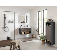 Modernes Badezimmer mit Dusche, Waschtisch, Spiegel, Hochschrank und natürlichen Elementen für eine helle und freundliche Atmosphäre.