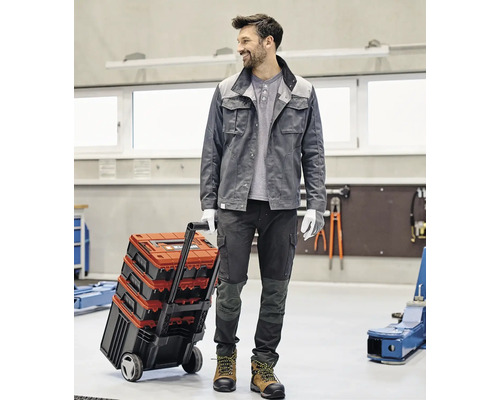 Handwerker mit Werkzeugkoffer Trolley in einer Werkstatt