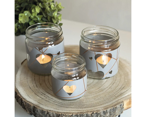 Dekorative Teelichthalter aus Glas mit Herzdesign auf Holzscheibe