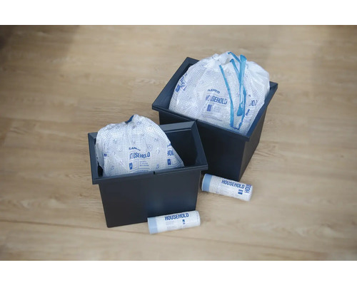 Zwei dunkle Behälter mit Wäschesäcken und zwei Rollen Wäschesäcke