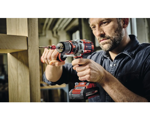 Ein Mann bohrt mit einem Akku-Bohrschrauber in ein Holzstück.