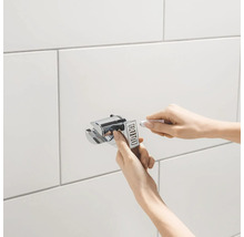 Montage einer Duschhalterung an einer gefliesten Wand.