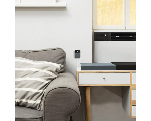 Graue Überwachungskamera an einer weissen Wand montiert