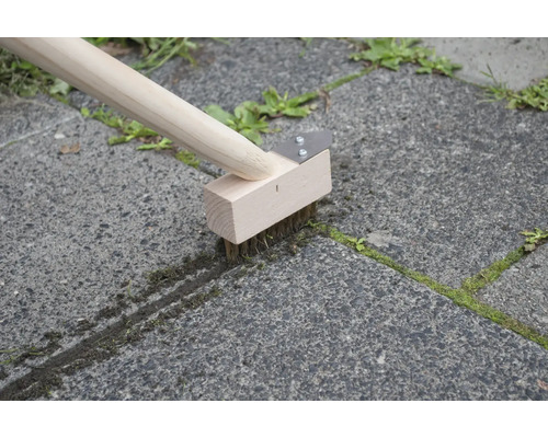 Fugenbürste mit Holzstiel im Einsatz zur Unkrautentfernung