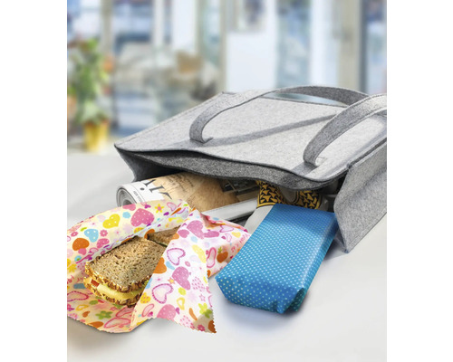 Graue Filztasche mit eingeschlagenen Lebensmitteln und einer Zeitung