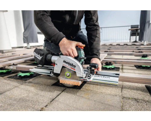 Handwerker sägt mit einer Metabo Akku-Kreissäge ein Holzbrett für eine Terrasse