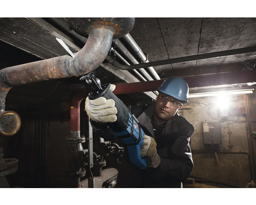 Handwerker mit Fuchsschwanz sägt Rohr