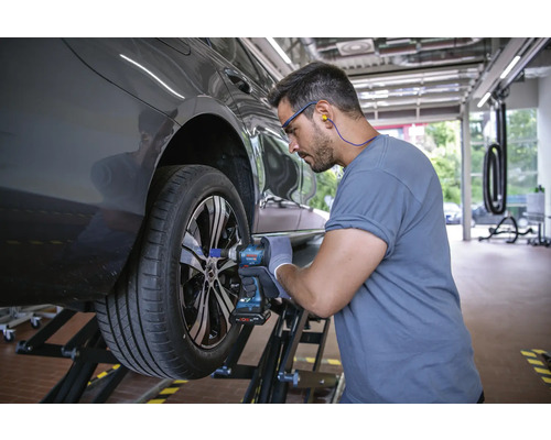 Ein Mechaniker wechselt ein Rad mit einem Akku-Schlagschrauber.