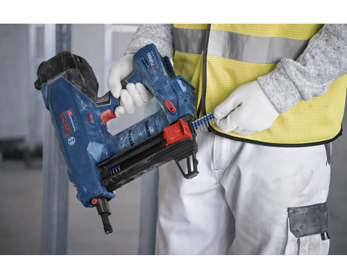 Eine Person lädt Klammern in ein Druckluftnagelgerät.