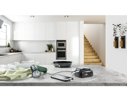 Szene einer Küche mit einem Akku-Reinigungspinsel, der ein Smartphone auflädt.