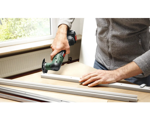 Mann arbeitet mit einem Multifunktionswerkzeug an Aluminiumprofilen