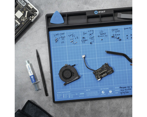 iFixit Reparaturset mit Schrauben, Werkzeugen und Wärmeleitpaste auf einer blauen Arbeitsmatte