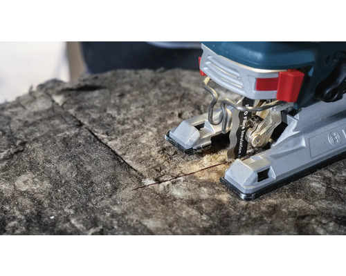 Nahaufnahme einer Stichsäge, die Dämmstoff schneidet.