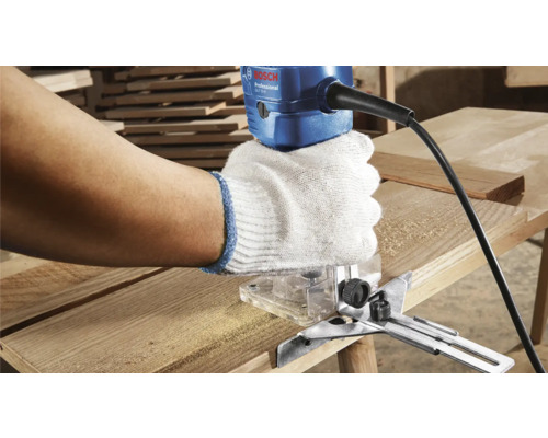 Handwerker benutzt Oberfräse mit Bosch Logo an Holzbrett