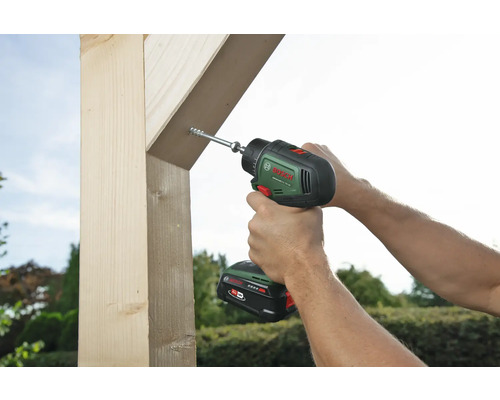 Eine Person schraubt mit einem Akku-Bohrschrauber eine Schraube in ein Holzstück.