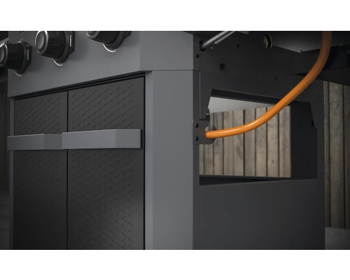 Detailansicht eines Gasgrills mit Schrankelementen und Gasleitung.