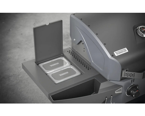 Tenneker Grill mit geöffnetem Seitenfach und zwei Behältern