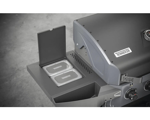 Detailansicht eines Gasgrills mit geöffnetem Warmhalterost und dem Tenneker Logo.