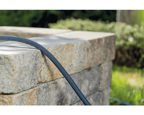 Gartenschlauch an einer Steinmauer